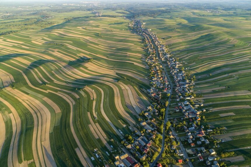 an aerial view of very long, narrow, undulating fields in rural Poland