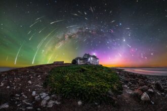 a glowing photograph of bright auroras, stars, and meteors over a mountain Croatian landscape with a house in the center