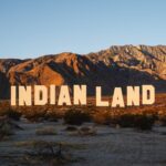 a large-scale installation in the desert resembling the Hollywood sign that reads "INDIAN LAND"