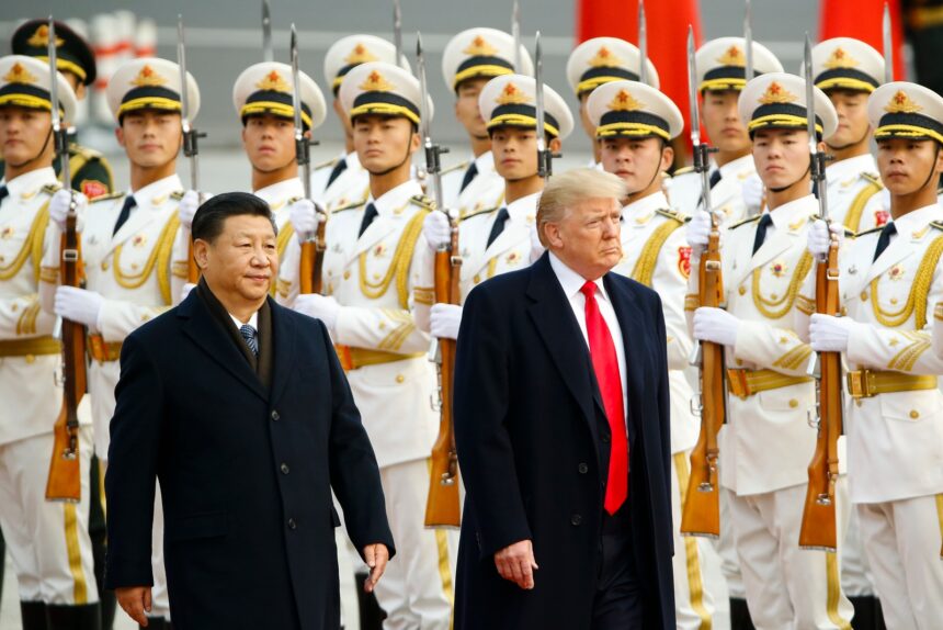 Donald Trump and Xi Jinping walk together in front of a group of uniformed Chinese soldiers.