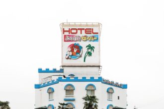 a bright white and blue facade of a castle-themed love hotel in Japan along the roadside