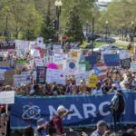 a crowd holding signs at the 2018 March for Science