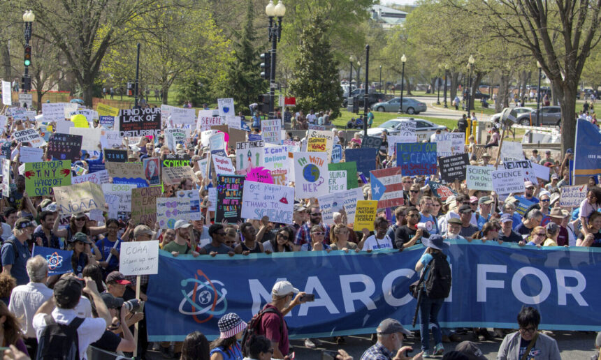 a crowd holding signs at the 2018 March for Science