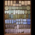 a tray of various shapes of ceramic pieces glazed with different colors