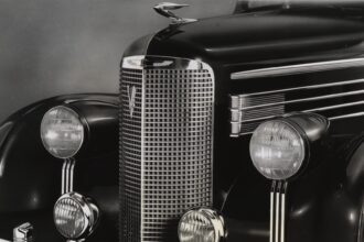 (Original Caption) 1938-Close-up of the very front end of a 1938 Cadillac La Salle. This smaller counterpart to the Cadillac features a smaller radiator grille, and four headlights, as well as the hood ornament and bumper.