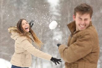 A couple having fun with a snowball fight.