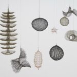 an installation view of abstract crocheted wire sculptures by Ruth Asawa