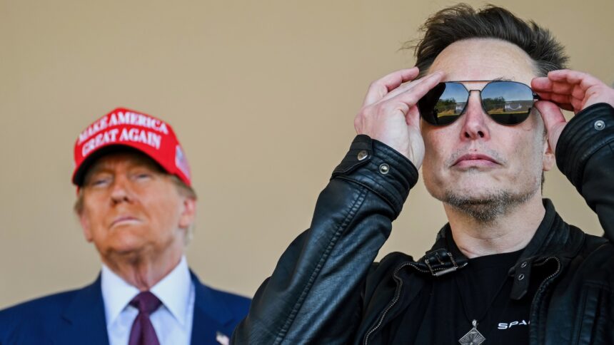 Elon Musk adjusts his sunglasses and Donald Trump looks on from two paces behind him. The two men are together to watch the launch of a SpaceX rocket.