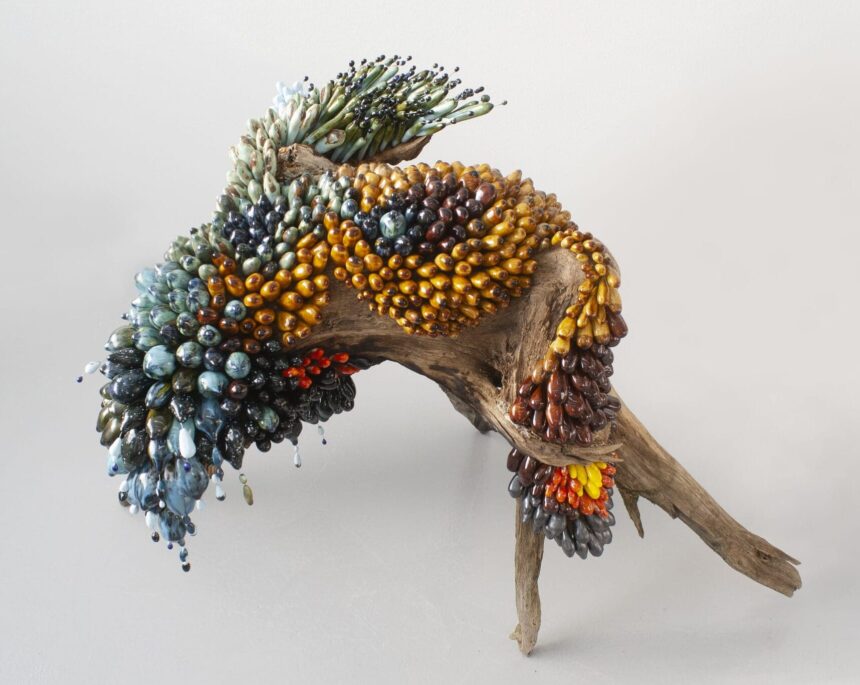 a botanical sculpture of bird, made from glass, wood, and ceramics