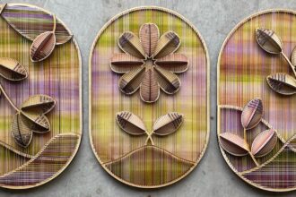 a trio of vibrant embroidered sculptural flowers on wood oval panels