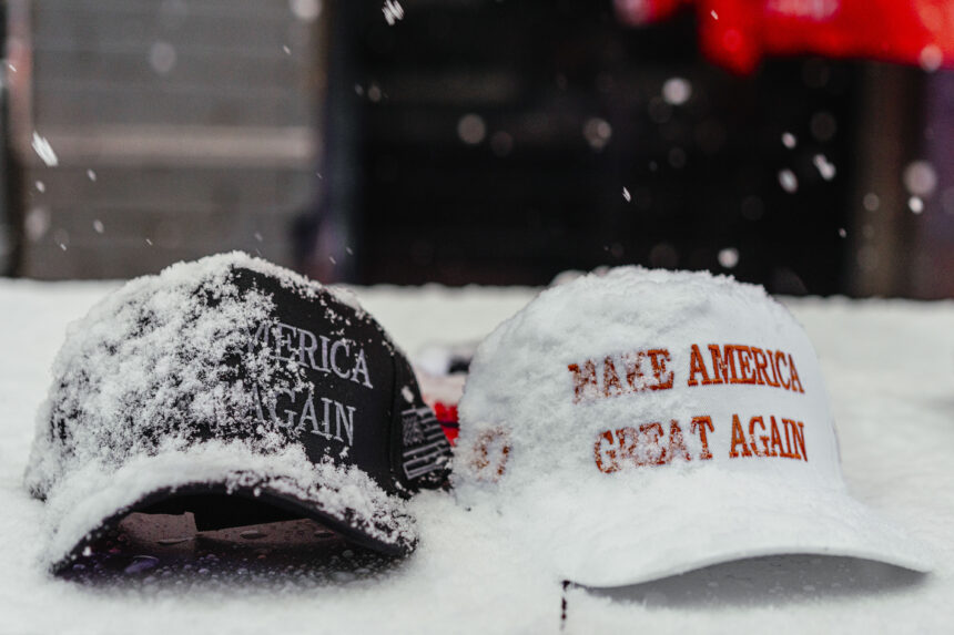 Snow covers MAGA hats for sale outside the rally.