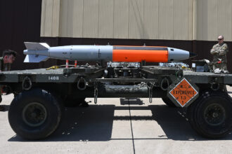 Military personnel are shown with a nuclear-capable weapons system during a test.